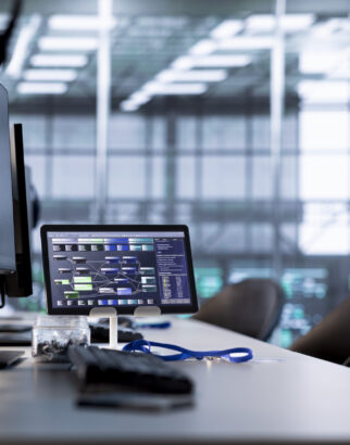 Lines of code running on computer screens and tablet in data center, troubleshooting rackmounts in server rows. Computing script working on PC monitors upgrading hardware